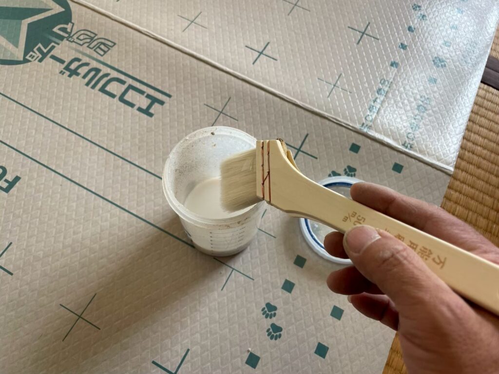 専用の糊を刷毛に含ませ、クロス施工の準備をします