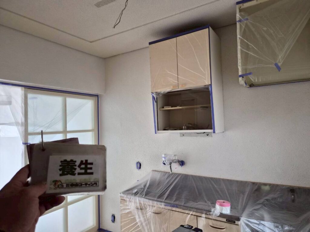 収納やキッチン設備もしっかりと養生し、塗装作業に備えます